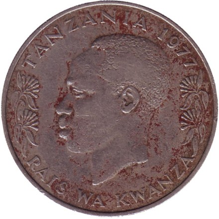 Монета 1 шиллинг. 1977 год, Танзания. Президент Али Хассан Мвиньи. Факел.
